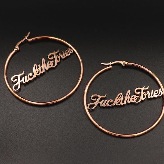 A pair of ‘Fuck The Tories’ hoop earrings by Topple & Burn – bold political jewellery made from surgical steel with gold or silver plating options.