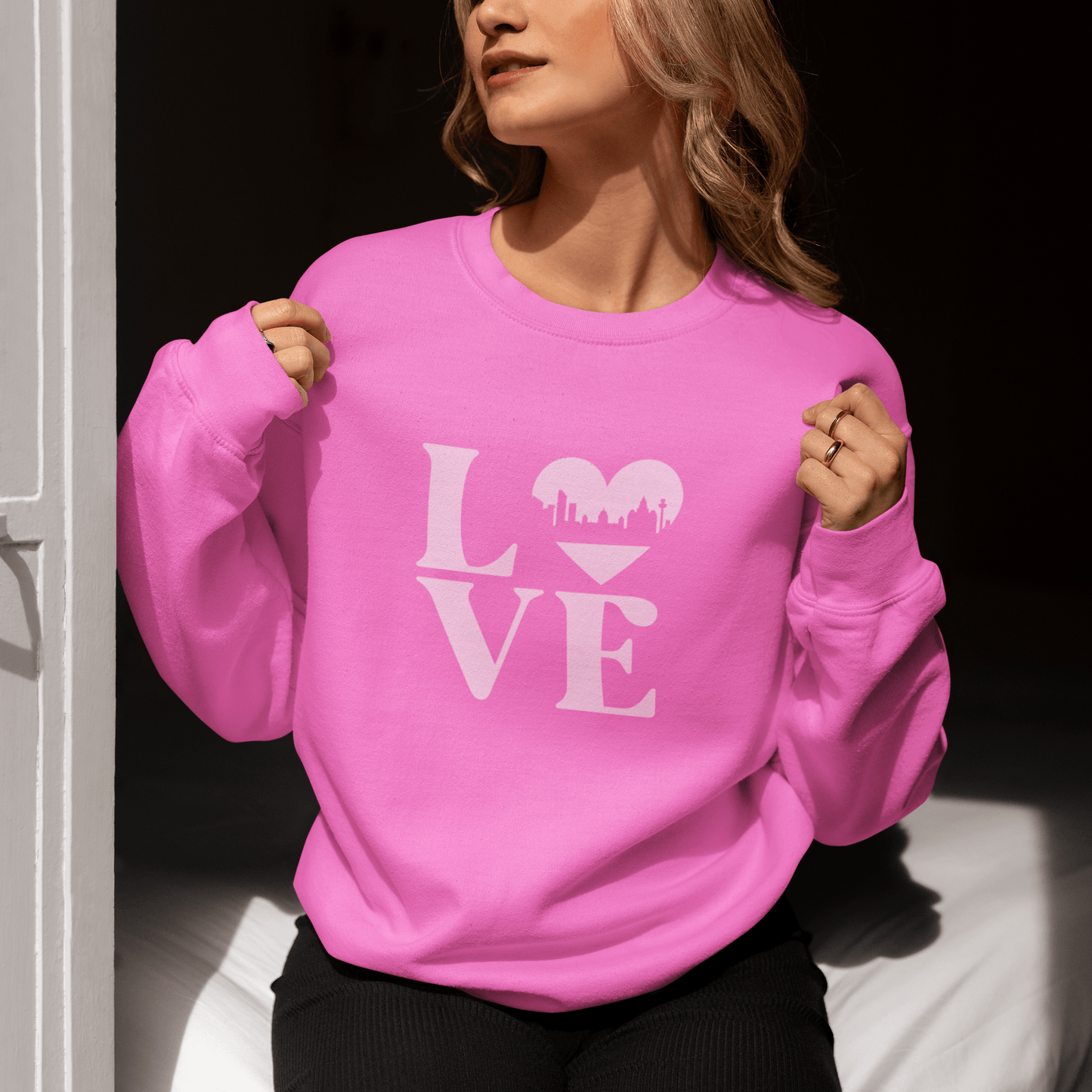 A pale pink Liverpool Love sweatshirt featuring the word LOVE, with a heart-shaped Liverpool skyline design – the perfect Liverpool gift or souvenir.
